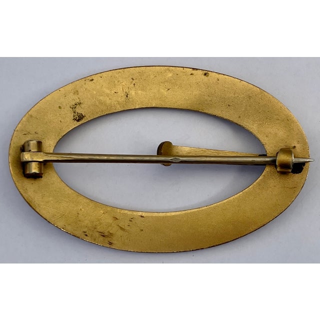 A handsome antique brass buckle brooch with etched flourishes and floral design all around. Acquired in France.