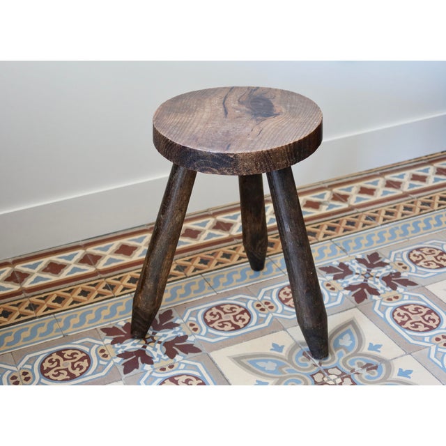 Dark wood tripod stool in a rustic and authentic style. Its simple three-legged design and beautiful patina give it plenty...