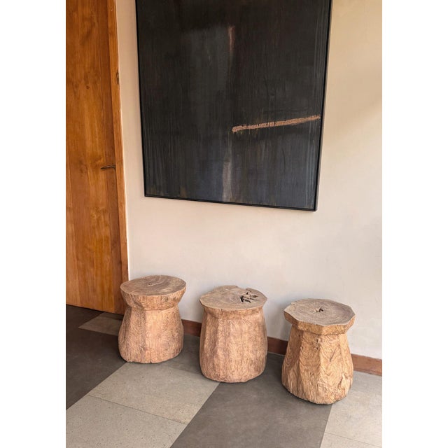 A striking antique teak wood side table originating from Java, Indonesia, showcasing the enduring beauty of aged timber...