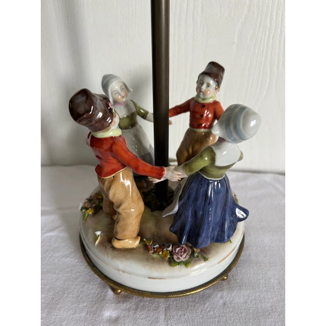 Sweet Porcelain Painted Girls and Boys wearing Dutch clothes and clogs. The girls are wearing a long navy skirt, an olive...