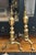 A 19th-century pair of brass andirons in classical architectural form with turned stems and claw feet, showing a warm,...