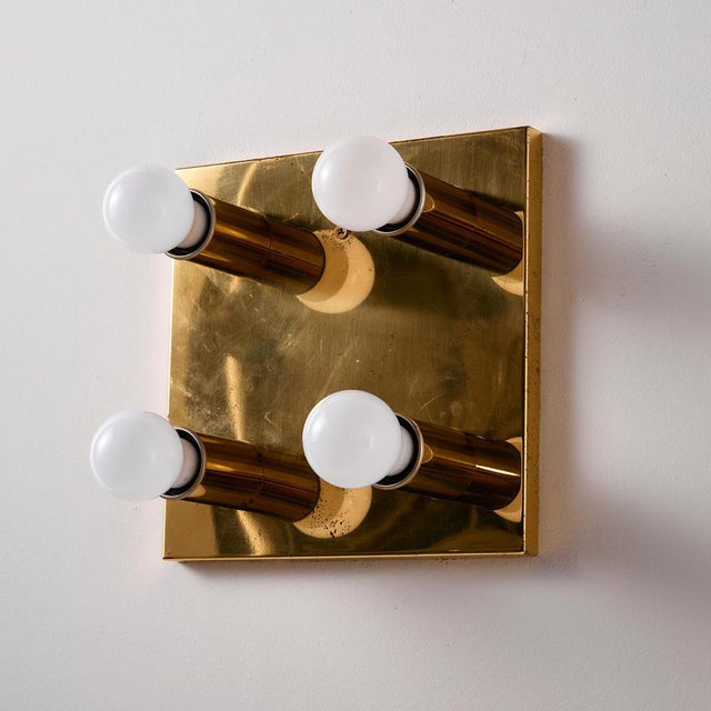 Brass wall lamp with four sockets from the 1970s. The brass surface of the lamp is oxidised with surface scratches and...