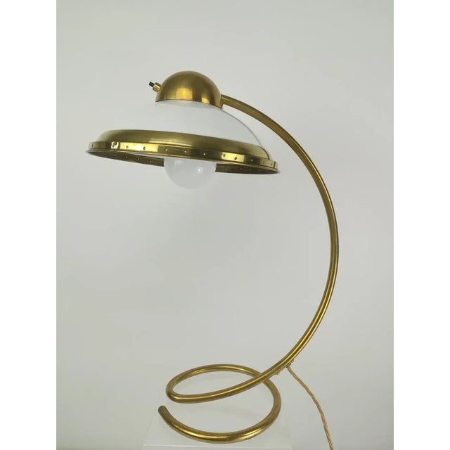 Polished brass pipe with glass shade, made in Germany. Height: 51 cm Diameter of the foot: 20 cm This piece is attributed...