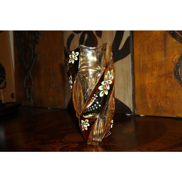 A captivating vintage-style art glass vase featuring a dramatic sculptural silhouette, warm amber tones, and delicate...