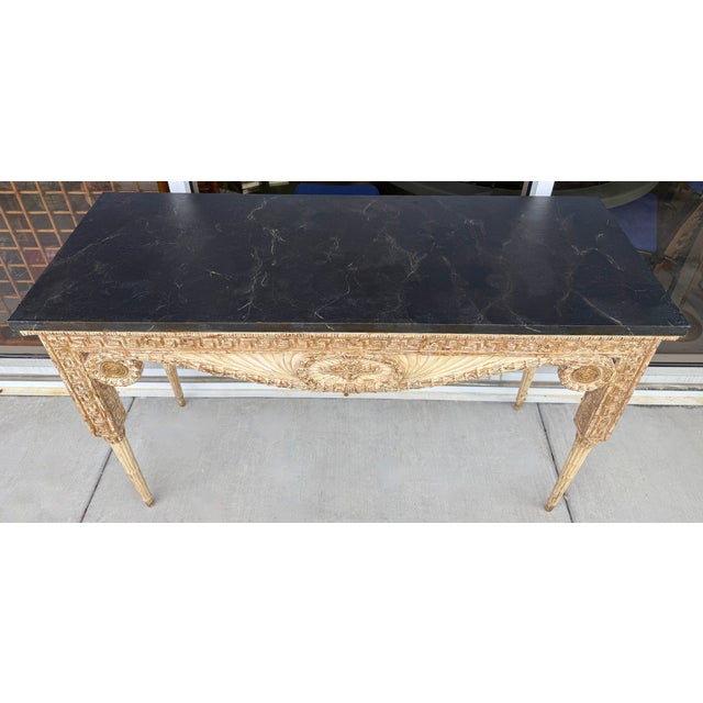 This is a Neoclassical style console table. It blends traditional French Louis XVI elements with Greek architectural...