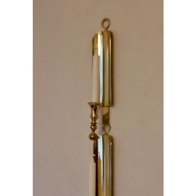 Made in Sweden. Two exquisite brass candle sconces from the Mid Century era, meticulously handcrafted with a stunning...
