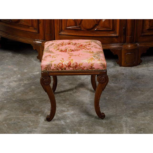 An English Regency period mahogany stool from the early 19th century, with cabriole legs and floral upholstery. Created in...