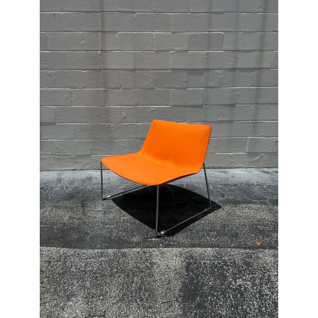 Defined by its generous proportions and clean, sculptural profile, this lounge chair pairs vibrant wool upholstery with a...