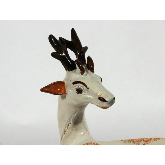 English Staffordshire Prattware Pottery Figure of a Recumbent Stag Circa 1800–1820 This appealing hollow-bodied pottery...