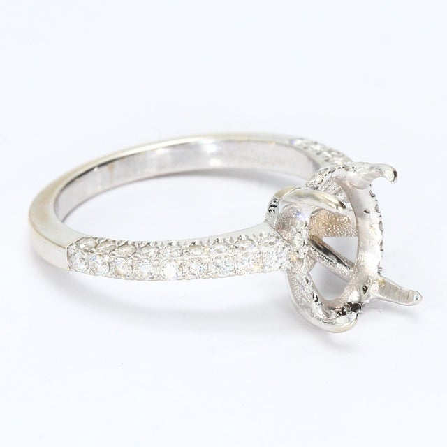 This is a 14k White Gold Engagement Ring with a Prong Setting for an Oval Center Stone. The Band is Adorned with Round...