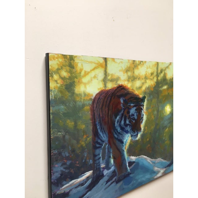 This oil painting on wood panel captures a solitary tiger poised on a rocky outcrop, set against a backdrop of softly...