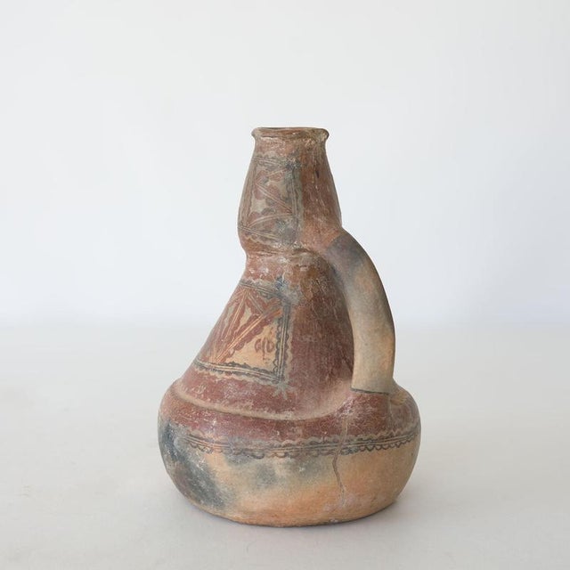 A traditional hand-crafted terracotta jug, known as a Takduht , originating from the Aït Chenacha region of Greater...
