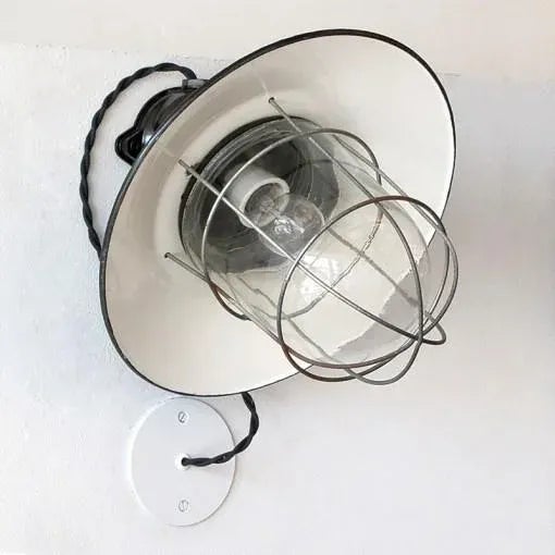Great pair of German Industrial wall lights with bakelite housings, enameled metal shades and a metal cages enveloping...