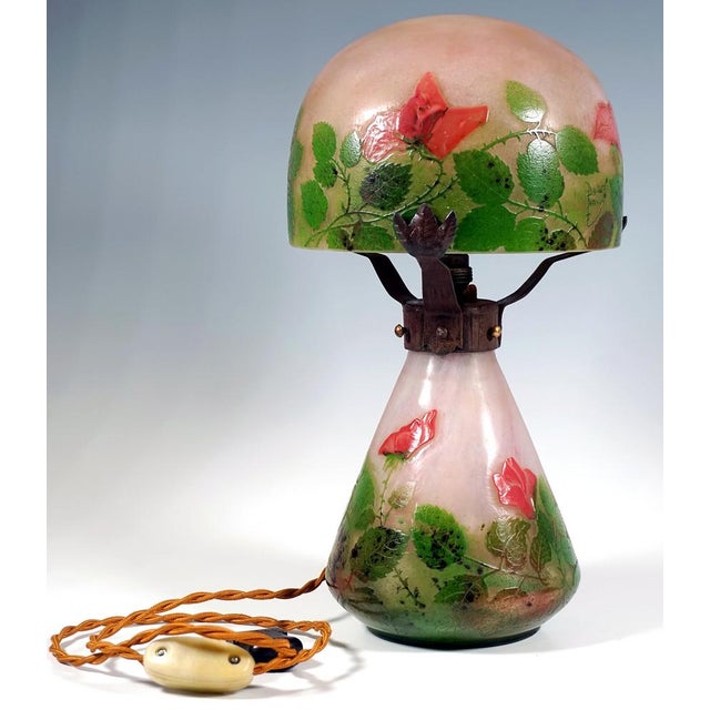 A beautiful piece of french art nouveau glass art: lamp with a conical base on a ring stand, dome-shaped shade made of...