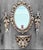Decorative oval mirror with matching wall sconces and coordinating shelf. Intricate carved scrollwork and fleur-de-lis...