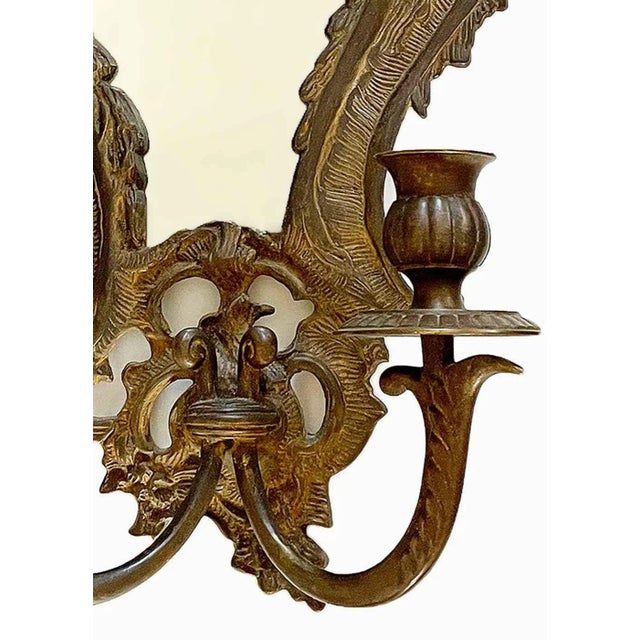 Pair of antique early 20th century bronze wall sconces. Two arm with original mirrors and four clear glass wax catchers....