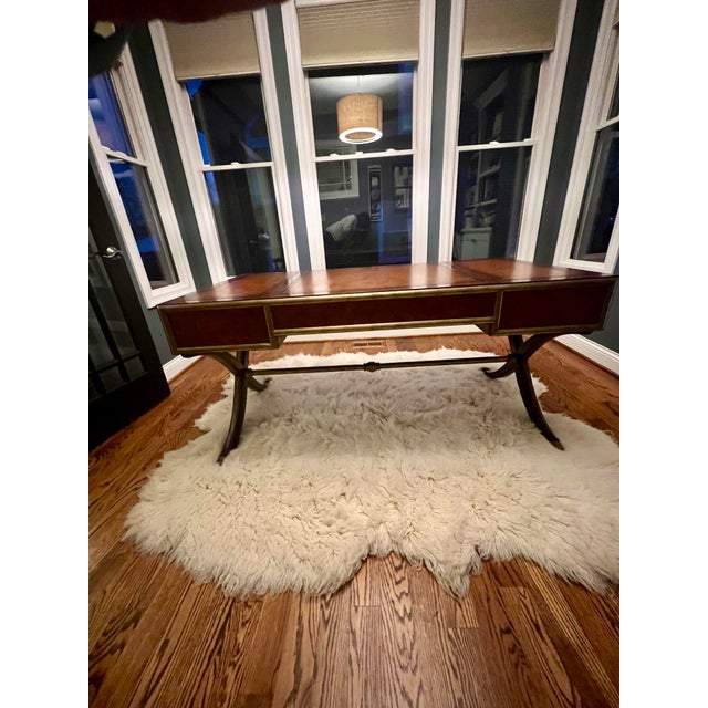 Leather topped correspondent's desk with brass accents. Curved legs. Three drawers. Extendable pullouts on either side....