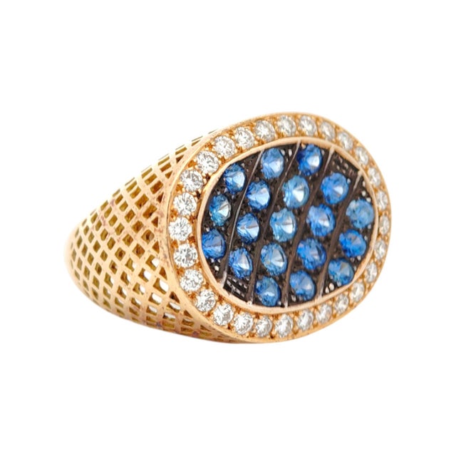 Crafted in 18K gold, this ring features a striking array of round-cut blue sapphires. The sapphires are elegantly set...