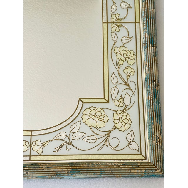 Mid 20 th c reverse painted glass mirror in blue and gold.