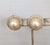 1980s goldtone round faux-pearl center with pavé round clear rhinestone clip earrings. Marked "CINER®" on the clips and...