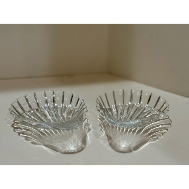 Elegant pair of Baccarat crystal dishes in the shape of a scallop shell. Features brilliant ribbed detailing that...