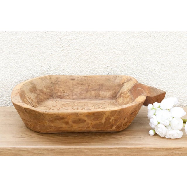 A study in contrast, where a rugged exterior hides a beautiful secret. This hand-carved wooden bowl is a remarkable piece...