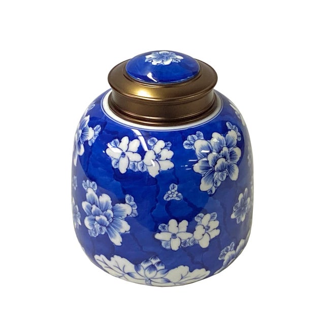 This is a quality handmade porcelain box container urn with a metal lid. The handpainted white color floral graphic...