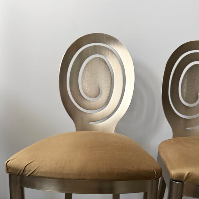 Set of three brushed nickel over steel spiral backed bar stools upholstered in a neutral olive satin crepe fabric. Great...