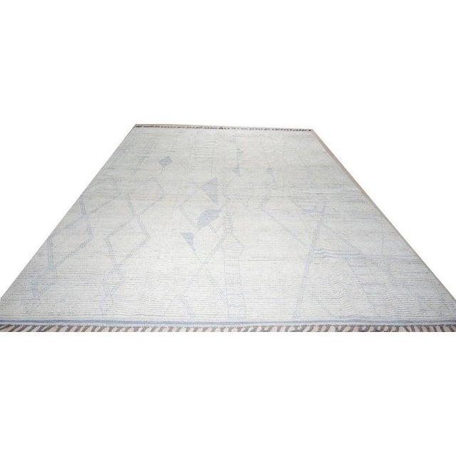 This hand knotted pile rug is crafted from wool and features a neutral color palette of ivory, beige, cream, and white....