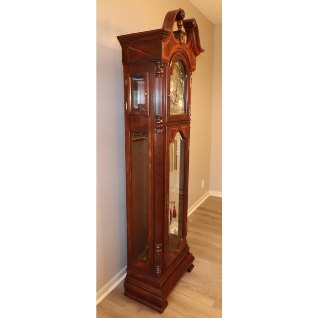 An exceptional Howard Miller Presidential Collection grandfather clock featuring an ornate swan-neck bonnet, richly...
