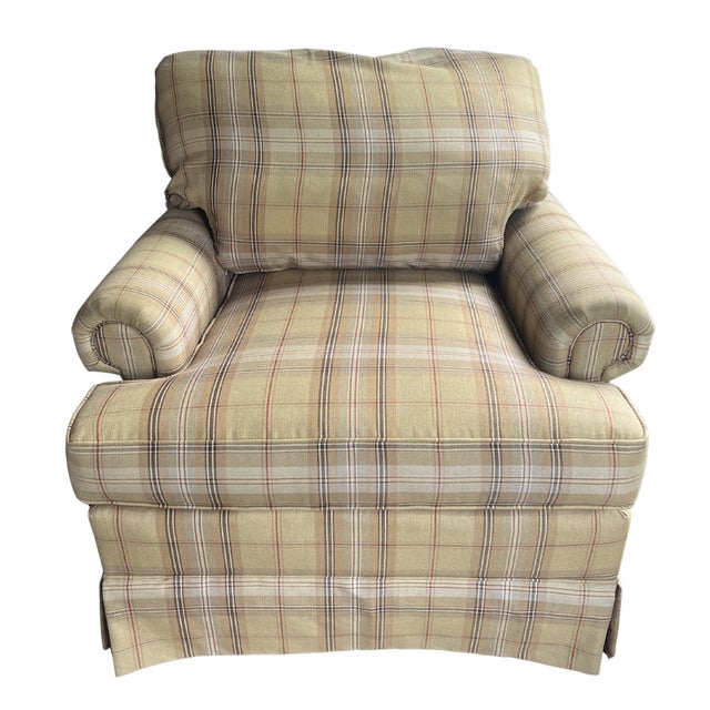 Pair of classic upholstered club chairs featuring a warm beige plaid fabric with brown, cream, and subtle red striping....