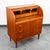 Danish teak secretary desk with a rolltop design and slide-out desk surface. Locking top surface rolls open and closes...