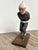 A whimsical carved wooden ice skater mounted on a rectangular wooden base, carved from one piece of wood with a great...