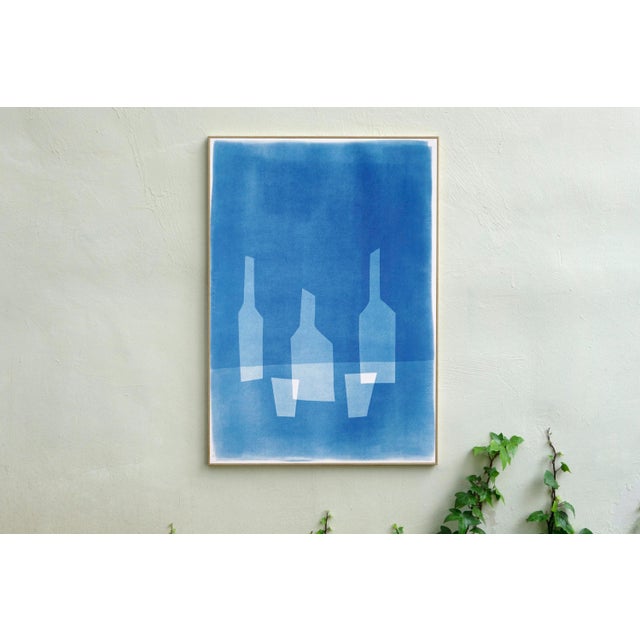 "Three Bottles for Two People" is an exclusive handprinted unique cyanotype made by layering paper cutouts of bottle...