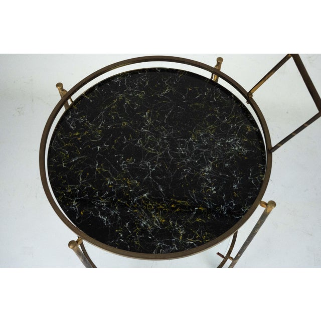 Elegant round bar cart in authentic 1950s style, featuring a refined brass frame and marble-effect glass shelf. The design...