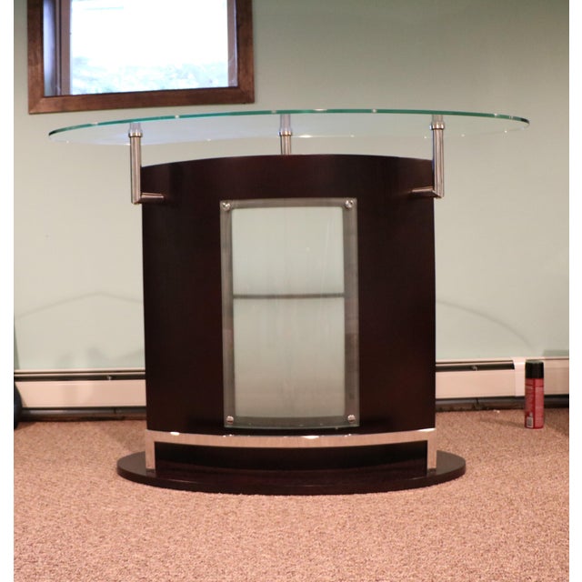 A cool and curvy dry bar with a glass top and glass and chrome accents that works equally well with an Art Deco or Mid-...