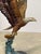 This dramatic bronze sculpture depicts a bald eagle descending with wings fully extended as it grasps a fish rising from...