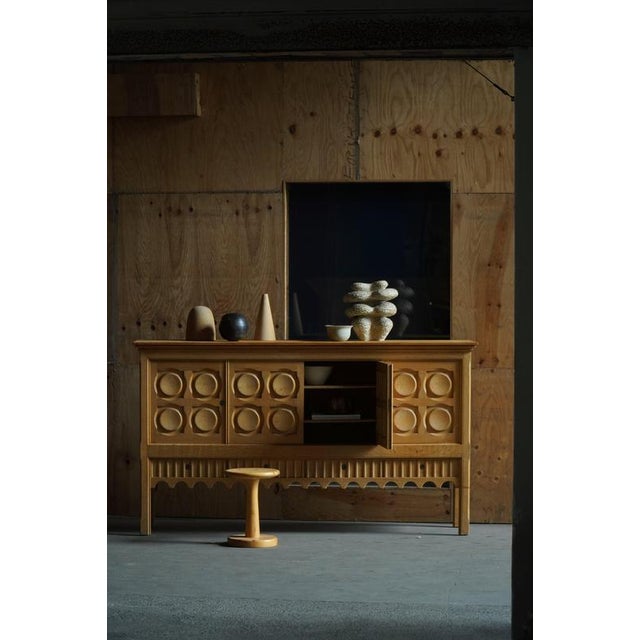 A beautiful and sculptural sideboard in solid oak, designed by Henning (Henry) Kjærnulf for Nyrup Møbelfabrik, Denmark,...