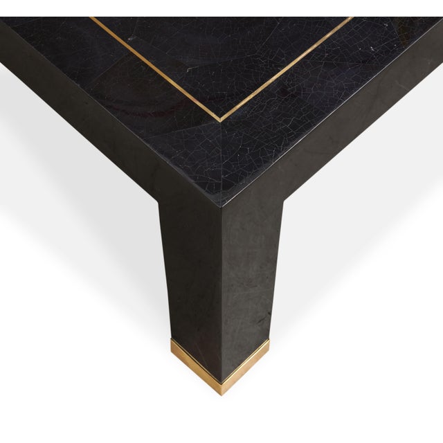 Crafted from deep brown penshell and real brass, this elegant Parsons style cocktail table brings texture and depth to...