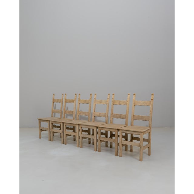 Set of Six 20th Century French Provincial Oak Ladder-Back Dining Chairs. Crafted in solid oak, this charming set features...