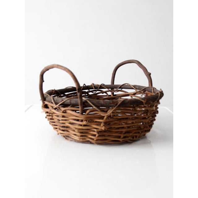 Charming mid-century handwoven vine basket with naturally rustic character and organic appeal. Crafted from intertwined...