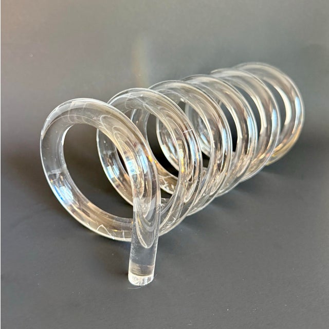Here is a vintage lucite spiral, likely dating to the 1950s–1960s, featuring a bold coiled form in clear acrylic. The...