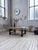 Vintage coffee table with a sculpted composite-stone top, resembling ceramic. It rests on a clean-lined metal base,...