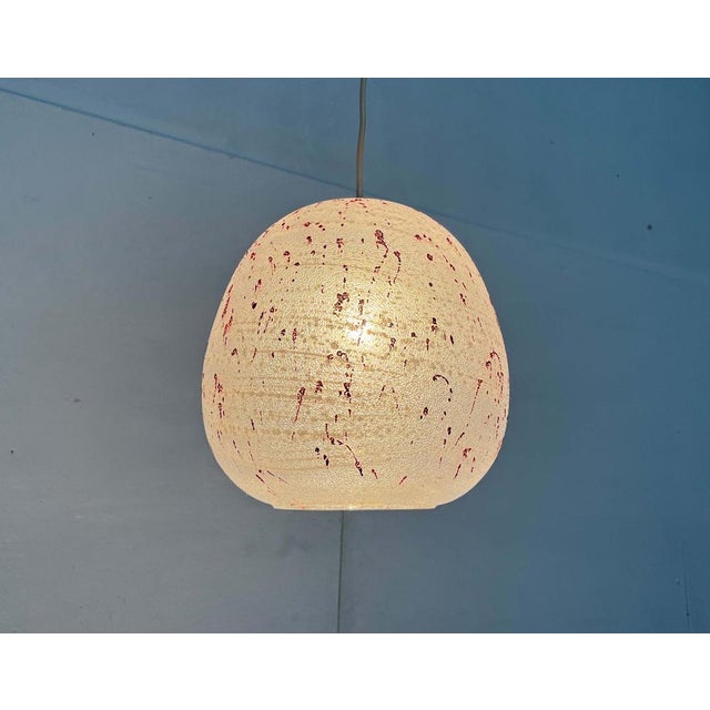 Space Age glass pendant light with distinctive ornamentation. The simple form of the frosted glass shade is enlivened by...