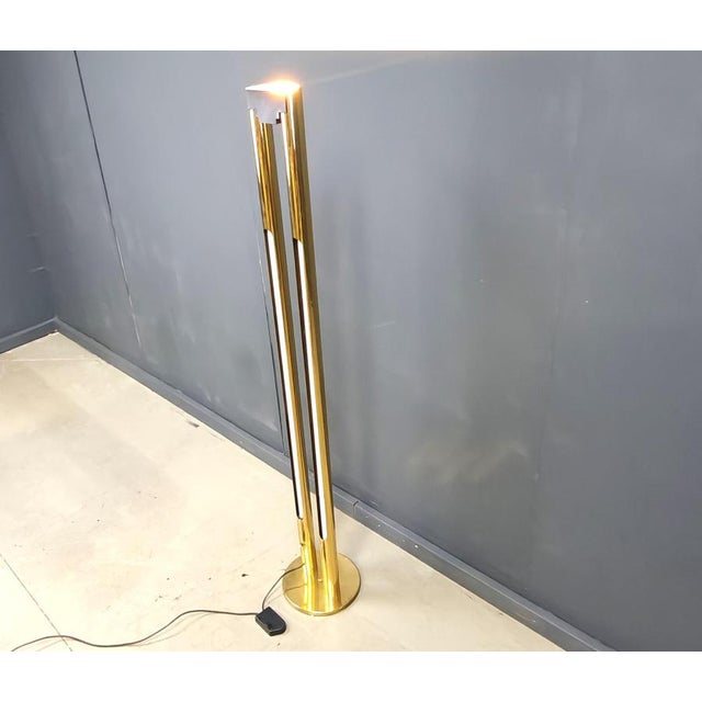 Modernist brass floor lamp featuring integrated white tube lights and an uand a dimmable lamp at the top. The top and tube...