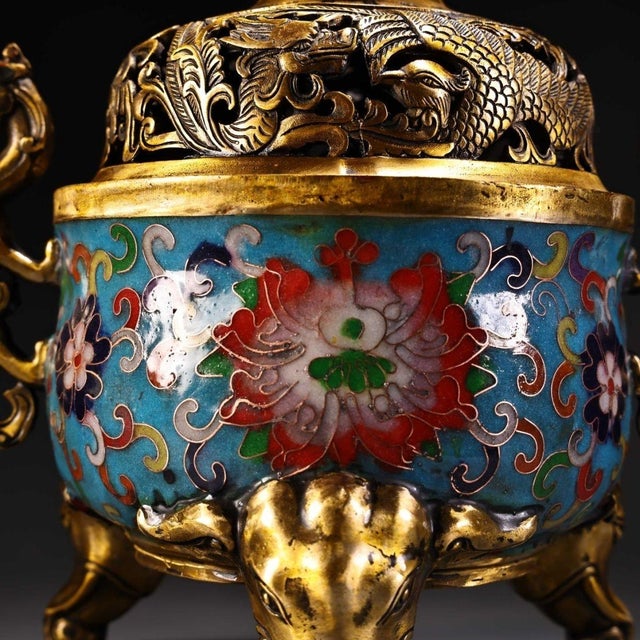 This ornate Chinese cloisonné incense burner features elaborately cast dragon‑form handles and tripod elephant‑head feet....