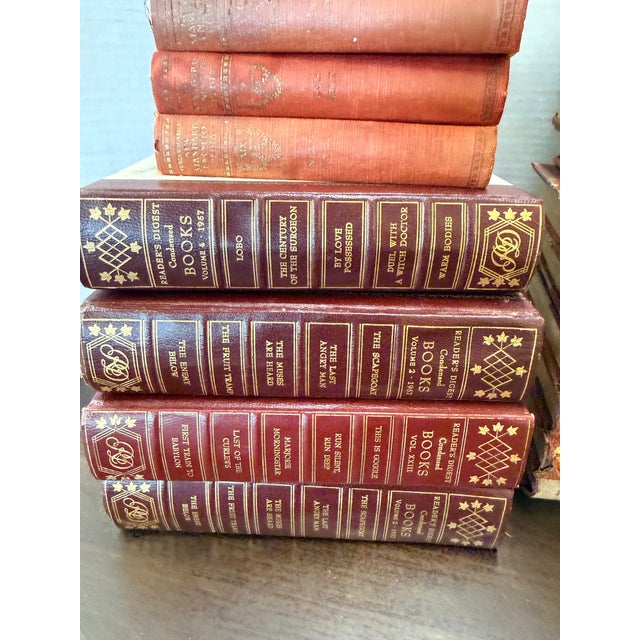 Charming collection of vintage hardcover books in warm shades of rust, burgundy and green with decorative gilt detailing....