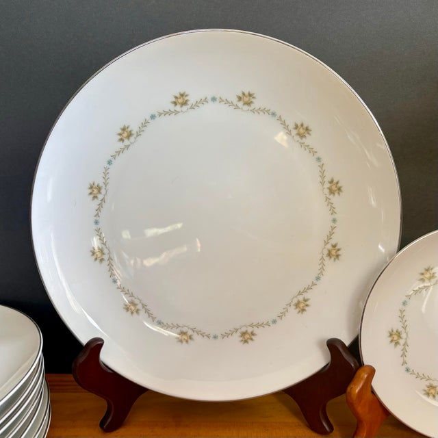 Beautiful vintage dinner plate from the Wyndham “Buttercup” pattern, featuring soft yellow and blue florals intertwined...