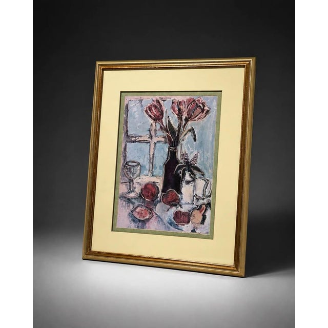 Framed floral still life artwork featuring flowers, fruit, glassware, and a table setting in a classic decorative style....