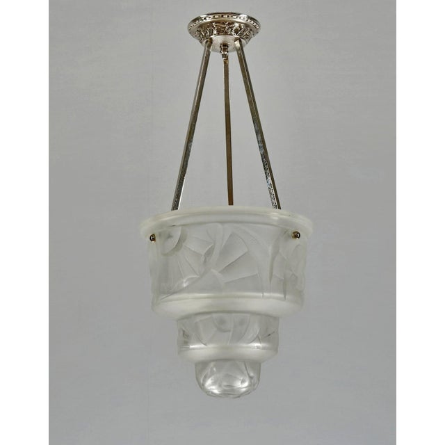 HUBENS & DEGUE A beautiful and rare 1928 - 1932 French art deco pendant chandelier. A nickel-plated fixture holds a deep...
